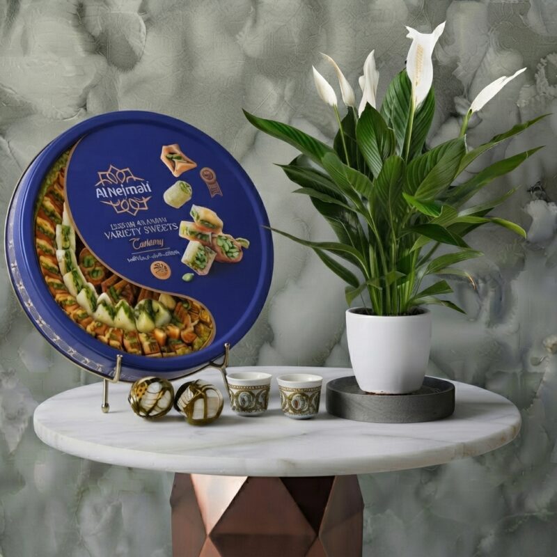A luxury plant and sweet gift bundle featuring a 1kg sweets box and a Peace Lily plant in Amman.تنسيق هدايا نباتات وحلويات