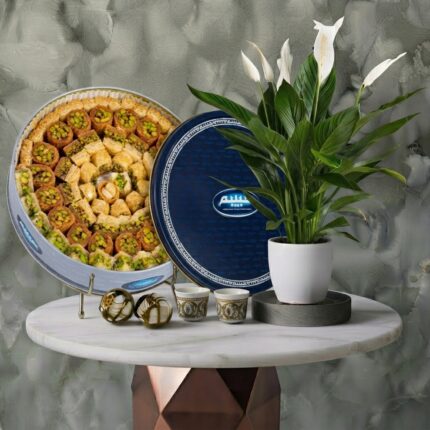 Circular tin of arabic sweets 900g from Habibah next to a peace lily plant in Amman.