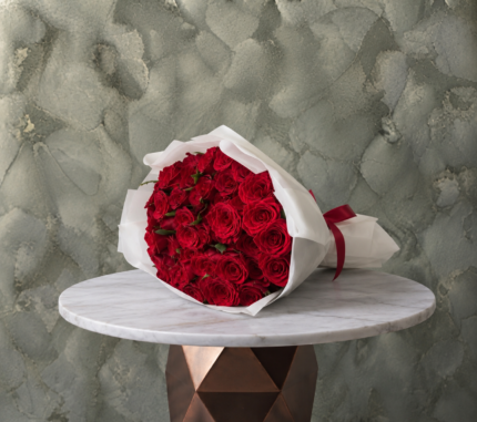 Red roses amman featuring a lush bouquet of premium red roses in white wrapping paper with a red ribbon.جوري الاحمر