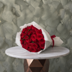 Red roses amman featuring a lush bouquet of premium red roses in white wrapping paper with a red ribbon.جوري الاحمر