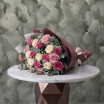 Pink and white roses bouquet amman featuring vibrant pink and cream roses with baby's breath and eucalyptus in elegant wrapping.