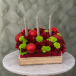 : صندوق شموع الكريسماس يحتوي على 3 شموع فضية وزهور الأقحوان في عمان-Christmas candle centerpiece featuring 3 silver candles and chrysanthemums in Amman.
