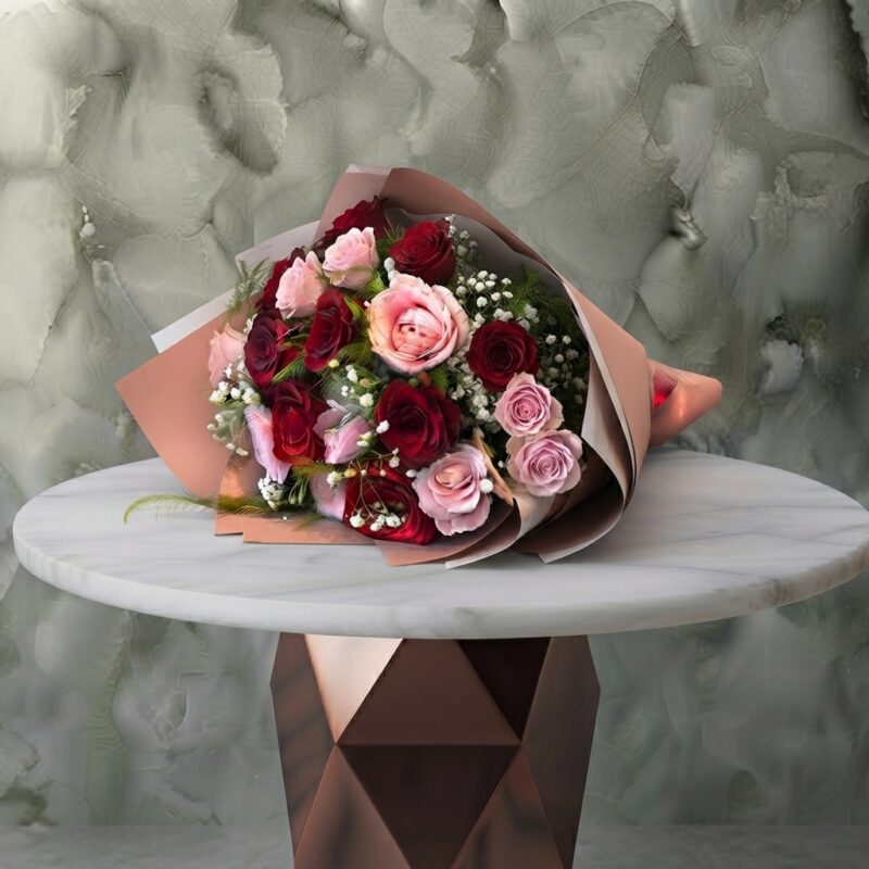Red and pink roses amman bouquet featuring striking red and soft pink roses with baby's breath in elegant wrapping.