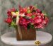 Luxury Christmas arrangement in a woven basket with red lilies, ornaments, and pinecones in Amman-تنسيق فاخر لعيد الميلاد في سلة قش مع ليليوم أحمر وكرات زينة وصنوبر في عمان.