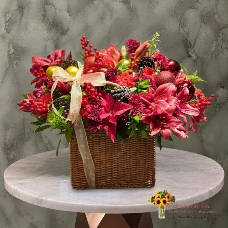 Luxury Christmas arrangement in a woven basket with red lilies, ornaments, and pinecones in Amman-تنسيق فاخر لعيد الميلاد في سلة قش مع ليليوم أحمر وكرات زينة وصنوبر في عمان.