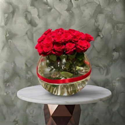 Elegant red love vase with 30 red roses in a spherical glass bowl with a red ribbon in Amman. مزهرية حب الحمراء زجاجية كروية تحتوي على 30 وردة جورية حمراء فاخرة وشريط أحمر في عمان.