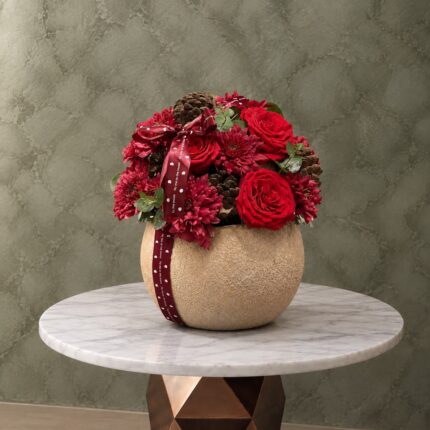 A red rose stone jar elegantly arranged in Amman-جرة ورد جوري أحمر بتصميم أنيق داخل إناء حجري في عمان.
