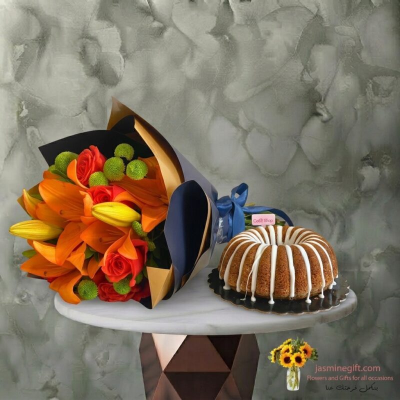 باقة زهور برتقالية مع كيك منزلي من كيك شوب موضوعة على طاولة في عمان-An orange bouquet with homemade cake from Cake Shop placed on a table in Amman