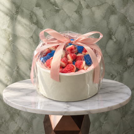 Round candy box amman featuring 500g of colorful assorted candies in a round box with a pink ribbon.بوكس كاندي دائري