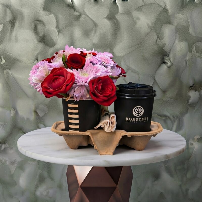 Blooming coffee amman gift featuring Roasters coffee cups paired with a vibrant arrangement of red roses and pink chrysanthemums in a carrier.قهوة مزهرة
