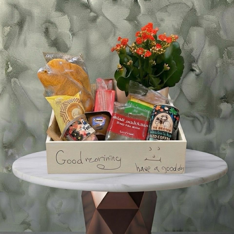 Morning Bliss Hamper - بوكس صباح السعادة Morning bliss hamper amman featuring a charming mini plant, croissants, juices, cakes, and coffee in a wooden box. بوكس صباح السعادة