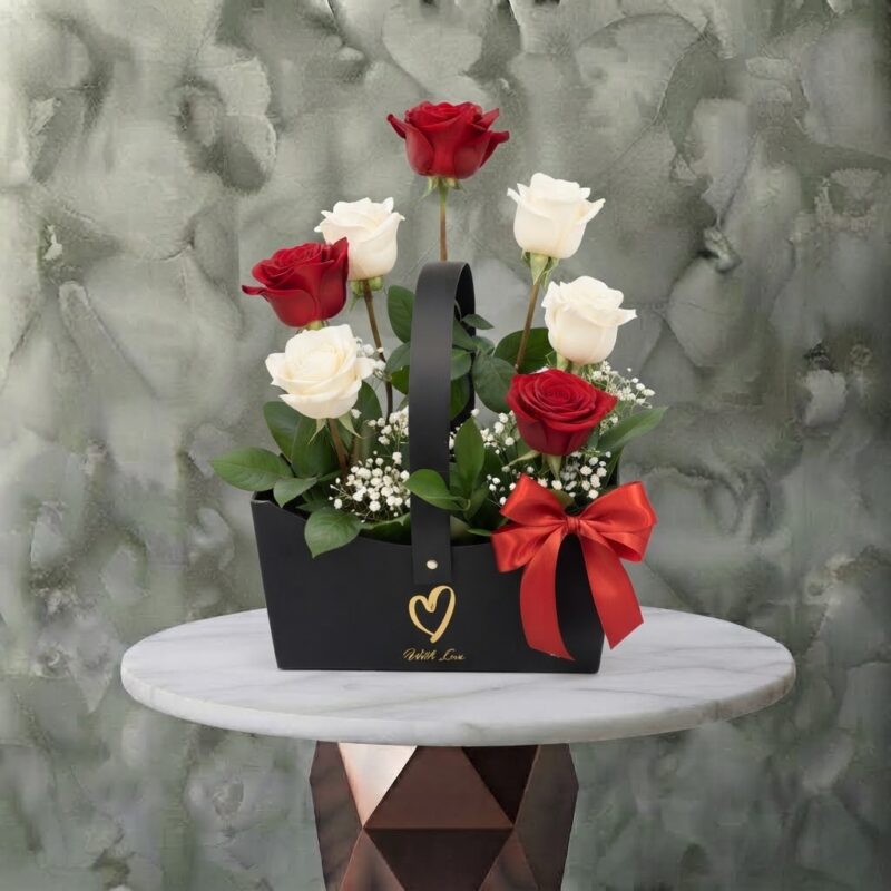 Just love amman arrangement featuring a stunning mix of red and white roses, baby's breath, and greenery in a black handle box with a red bow.