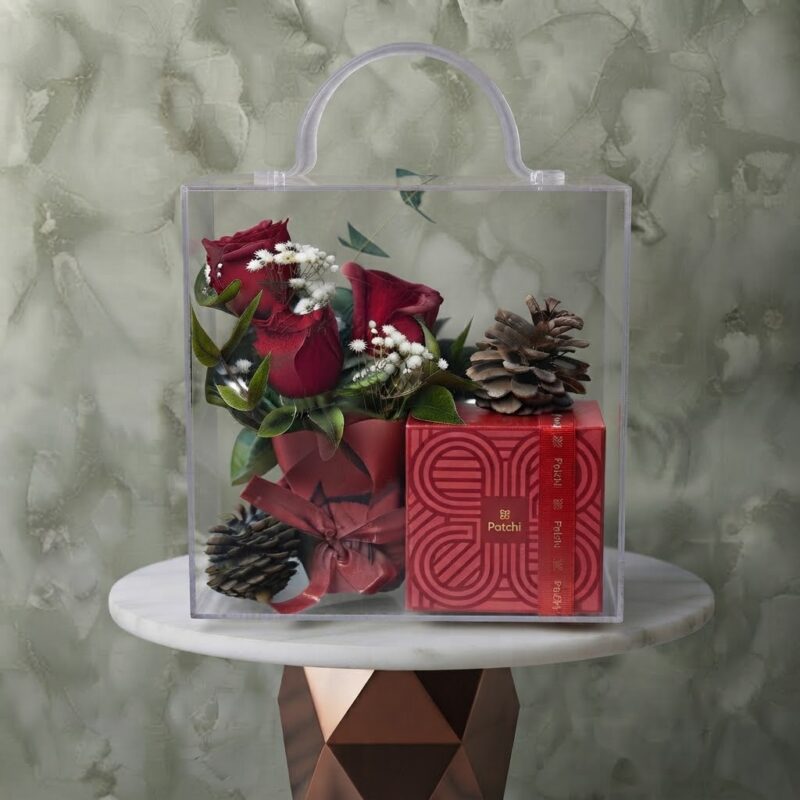 Patchi glow amman gift set featuring red roses, pinecones, and Patchi chocolates inside a clear acrylic handle bag.بريق باتشي