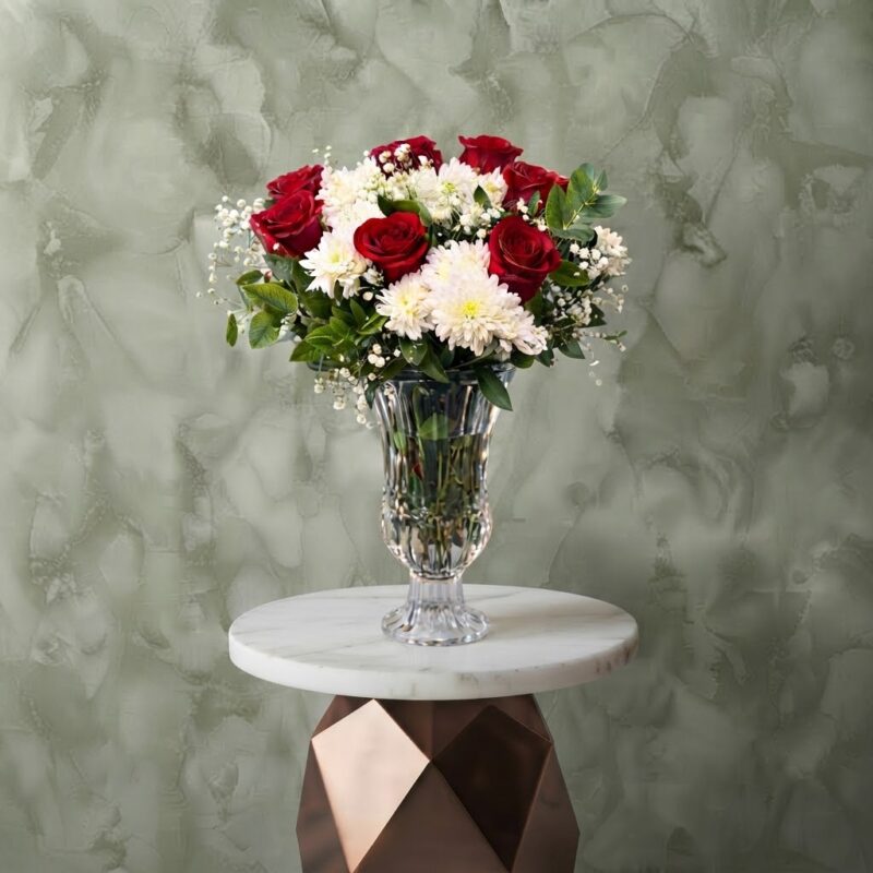 Rose radiance amman arrangement featuring red roses, white chrysanthemums, and baby's breath in a crystal clear glass vase.إشراقة الروز