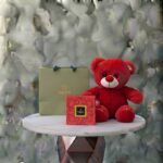 Sweet hug amman gift set featuring a soft red teddy bear, Patchi chocolate box, and a branded gift bag.