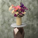 Gentle touch amman arrangement featuring pink lily and purple chrysanthemums in a yellow ribbed ceramic vase.